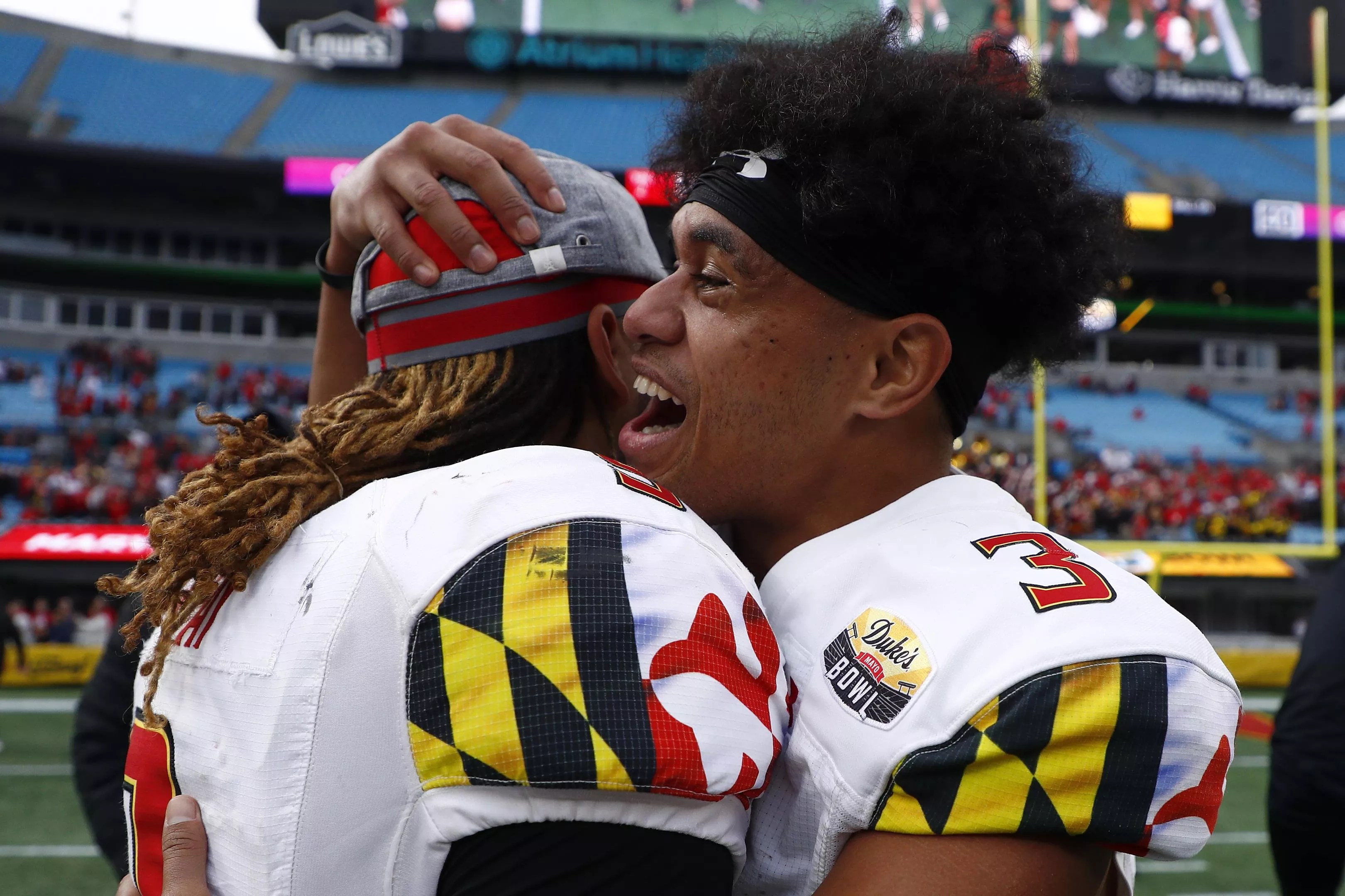Taulia Tagovailoa, brother of Miami Dolphins quarterback Tua Tagovailoa, smiles and hugs a teammate after a bowl game win