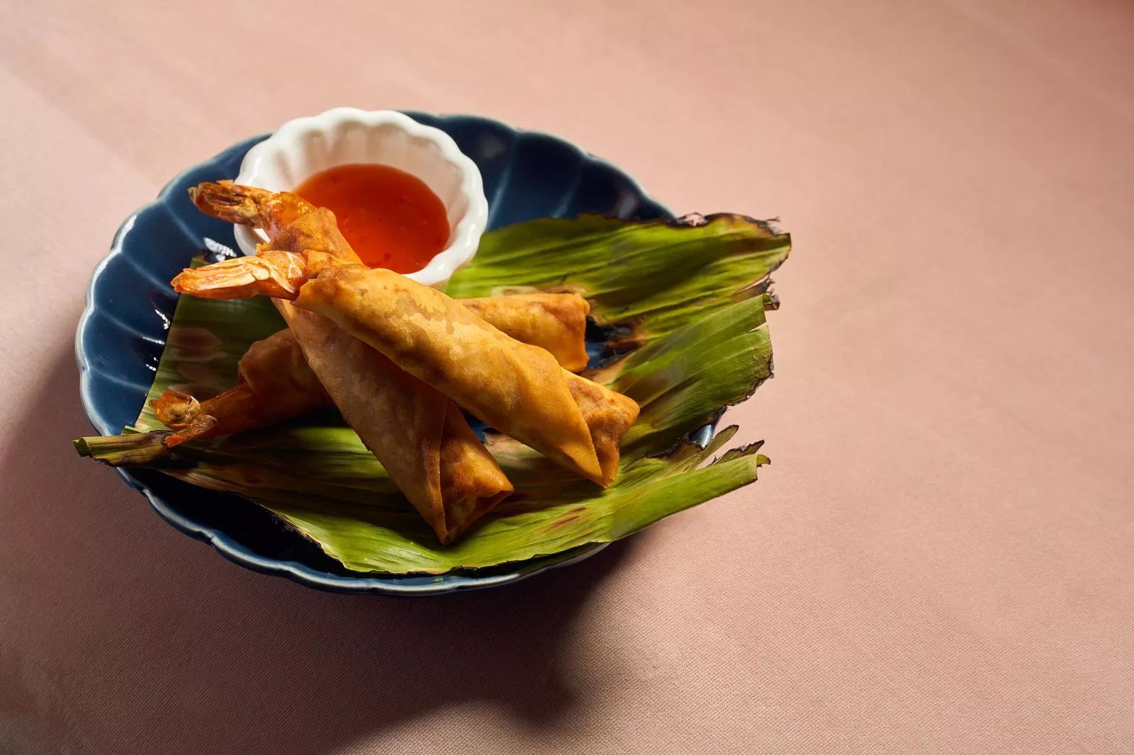 Asian food on a plate with pink background
