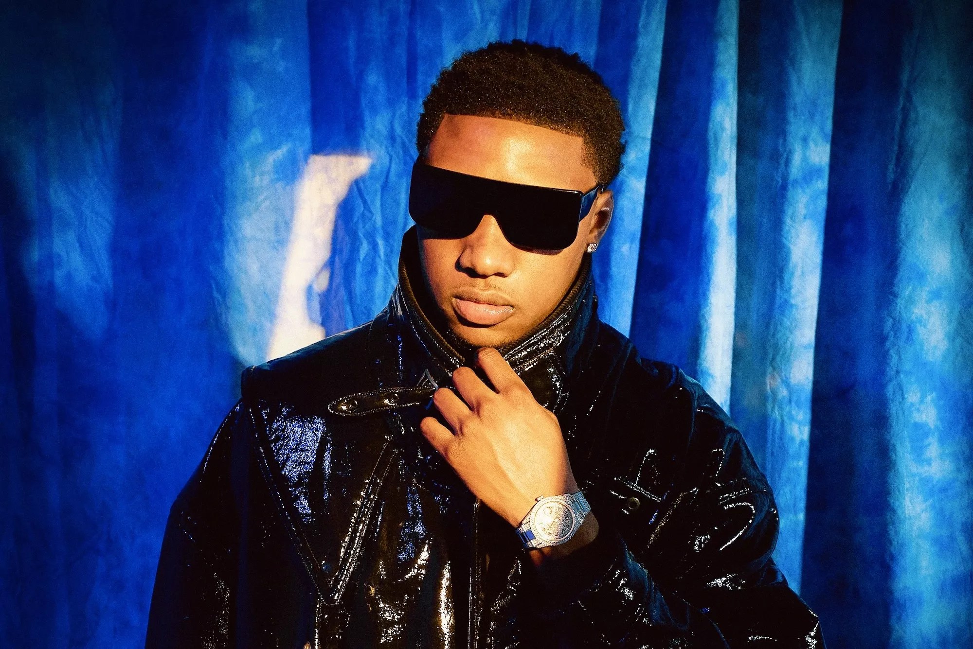 rob49 poses in a black top and sunglasses