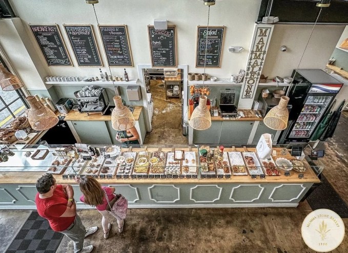 a bakery with pastel hues and pastries behind glass enclosures