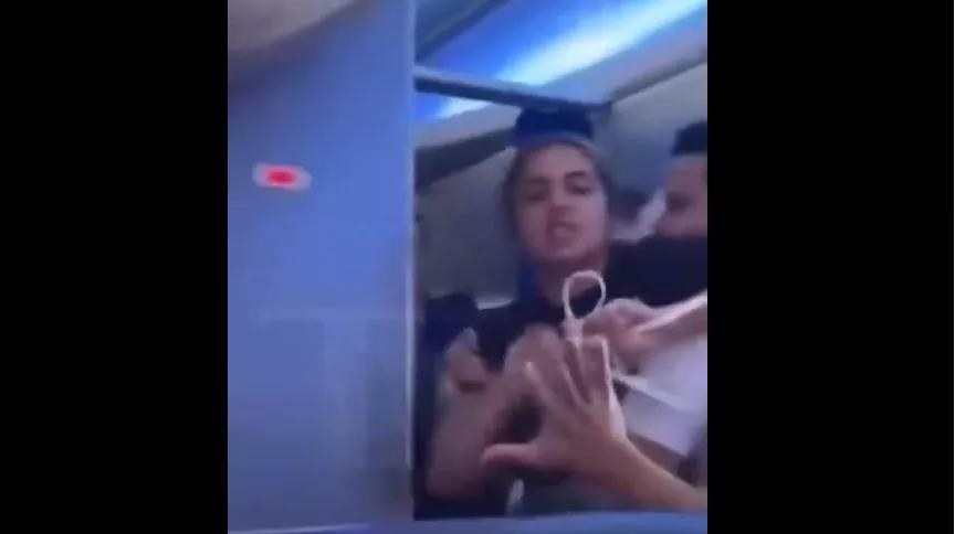 Enraged woman restrained by a flight attendant