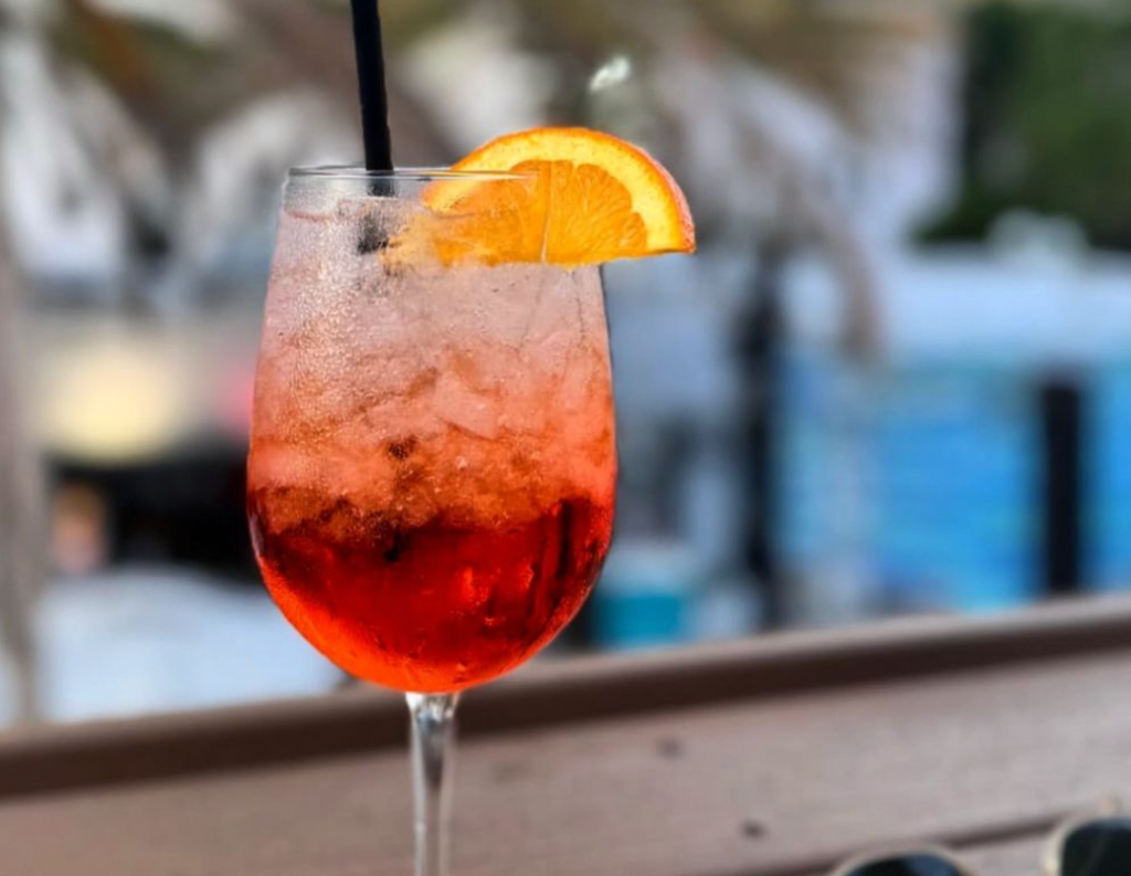 a cocktail with an orange wedge