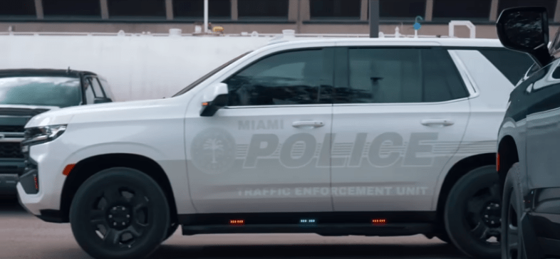 A white police SUV with faded labels to conceal police presence