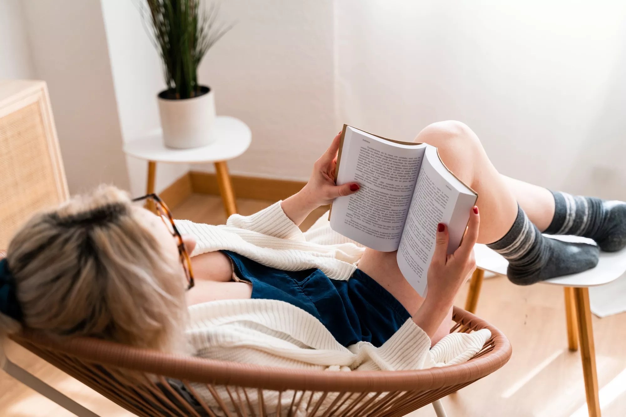 A woman sitting in a chair, reading a book