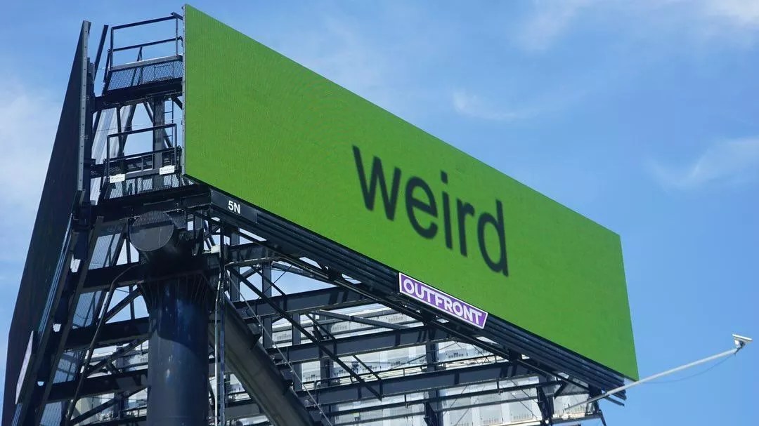 billboard with the word "weird" spelled out in lowercase sans serif letters against a bright green background