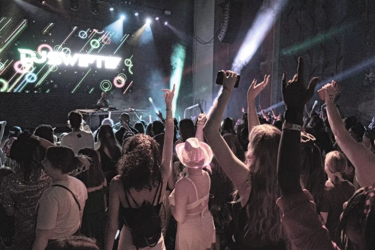 A crowd dancing in front of the stage with DJ Swiftie