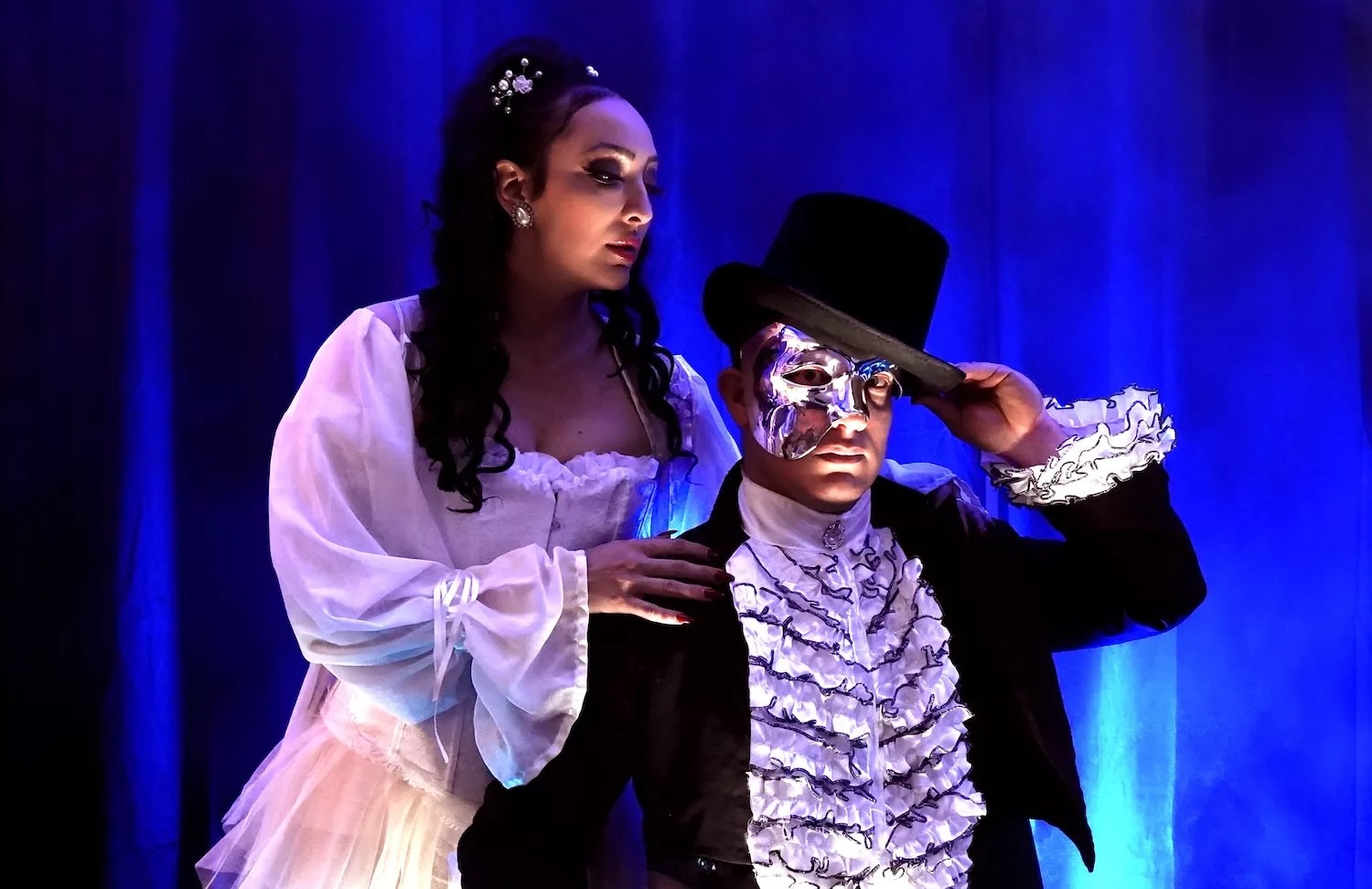 A well-dressed man and woman performing on a stage