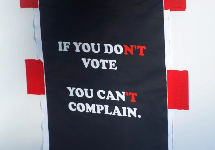 photo of a red, white, and blue sign that says "If you don't vote, you can't complain" but owing to its coloration can be read to say "if you do vote, you can complain"