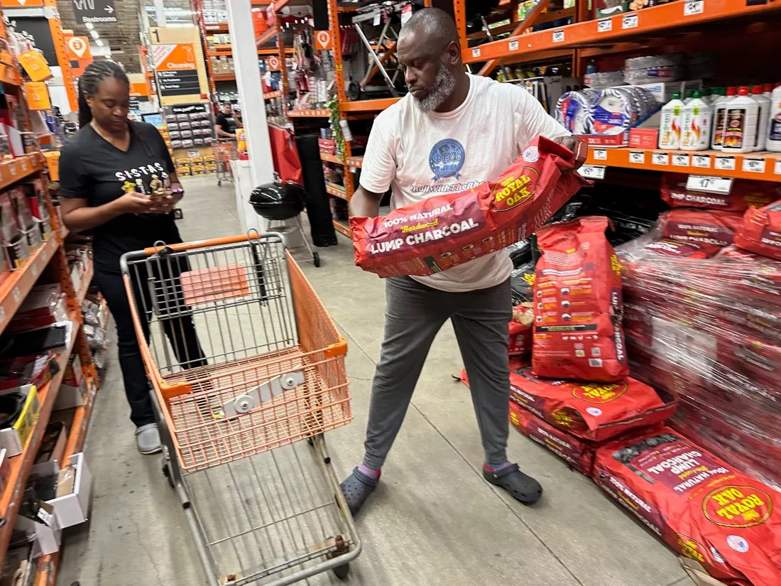 A man grabs a bag of charcoal at the North Miami Home Depot