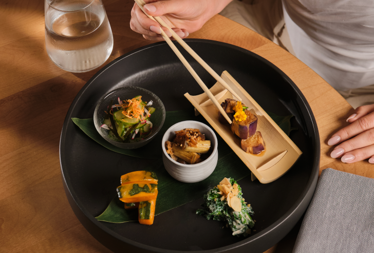 hand eating sushi with chopsticks