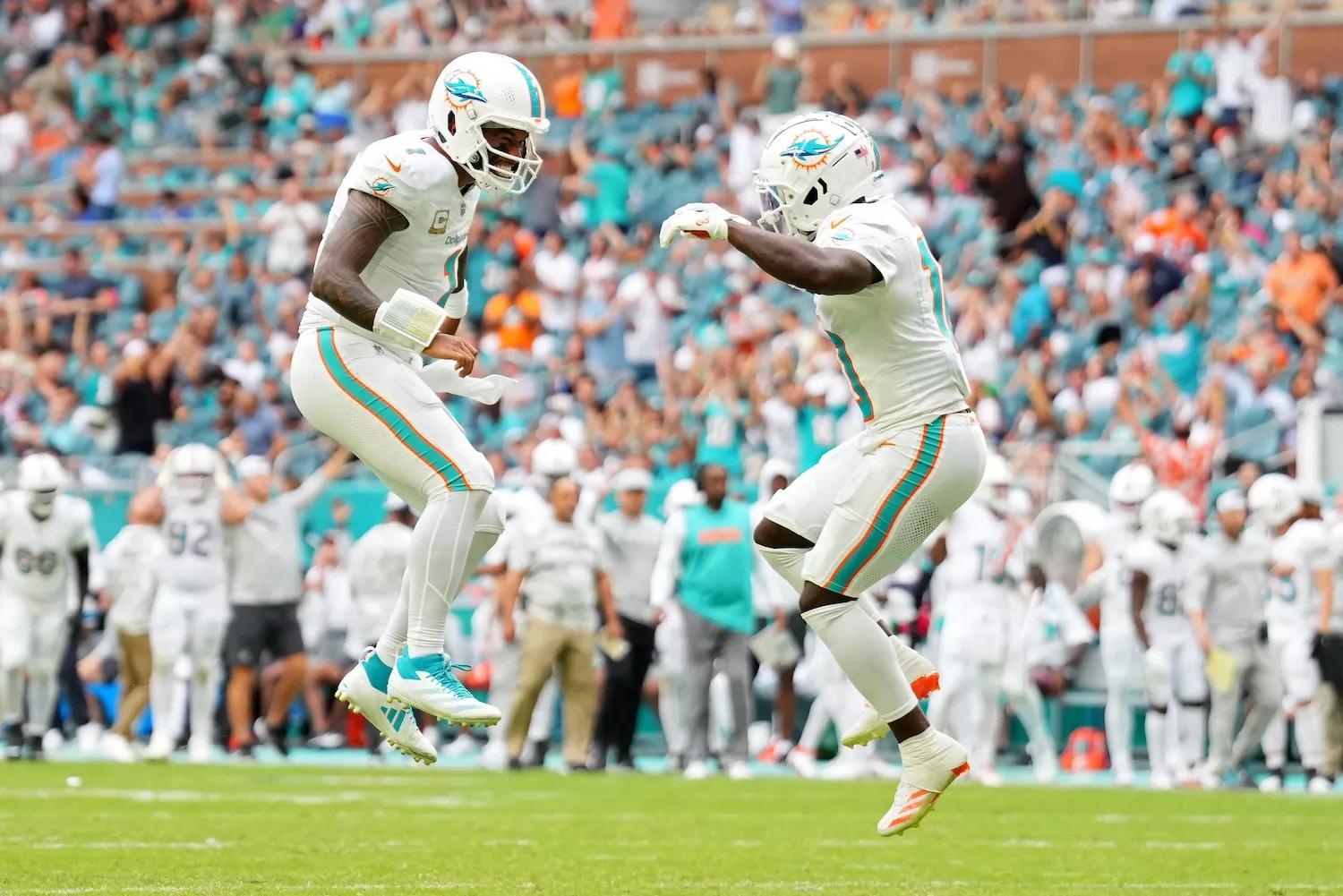 Tua Tagovailoa #1 and Tyreek Hill #10 of the Miami Dolphins celebrate after their team's rushing touchdown in the fourth quarter of a game against the Las Vegas Raiders at Hard Rock Stadium on November 17, 2024, in Miami Gardens, Florida.