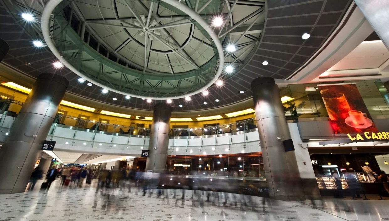 A long exposure of people walking through the gates of Miami International Airport