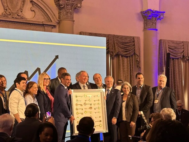 Hedge fund billionaire Ken Griffin standing alongside local leaders while being presented with honorary keys to nearly two dozen Miami-Dade cities.