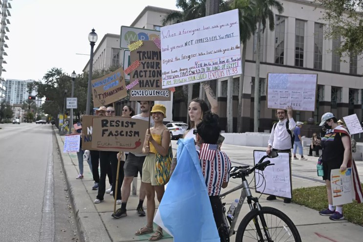 Protesters hold signs in West Palm Beach