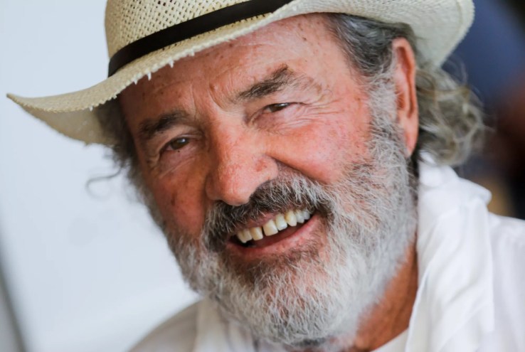 candid headshot of a smiling, gray-bearded Jack Penrod wearing a straw hat