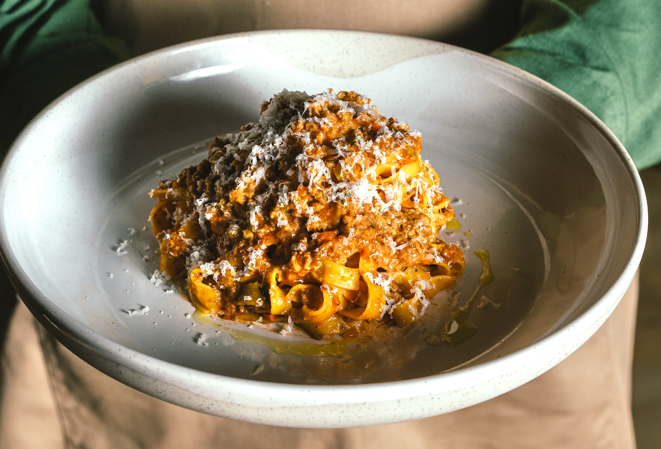 a meat pasta with cheese shavings