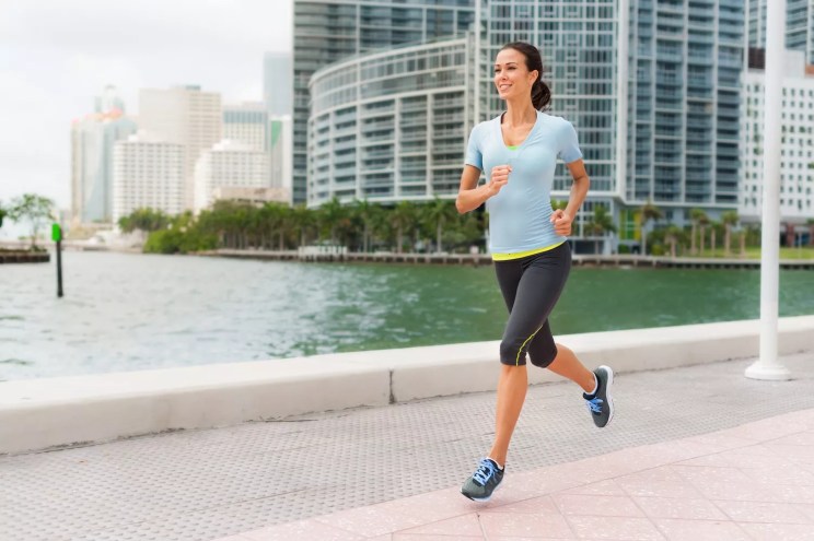 Young woman jogging near water in Miami's Brickell neighborhood