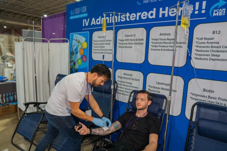 a man administers IV treatment to another man