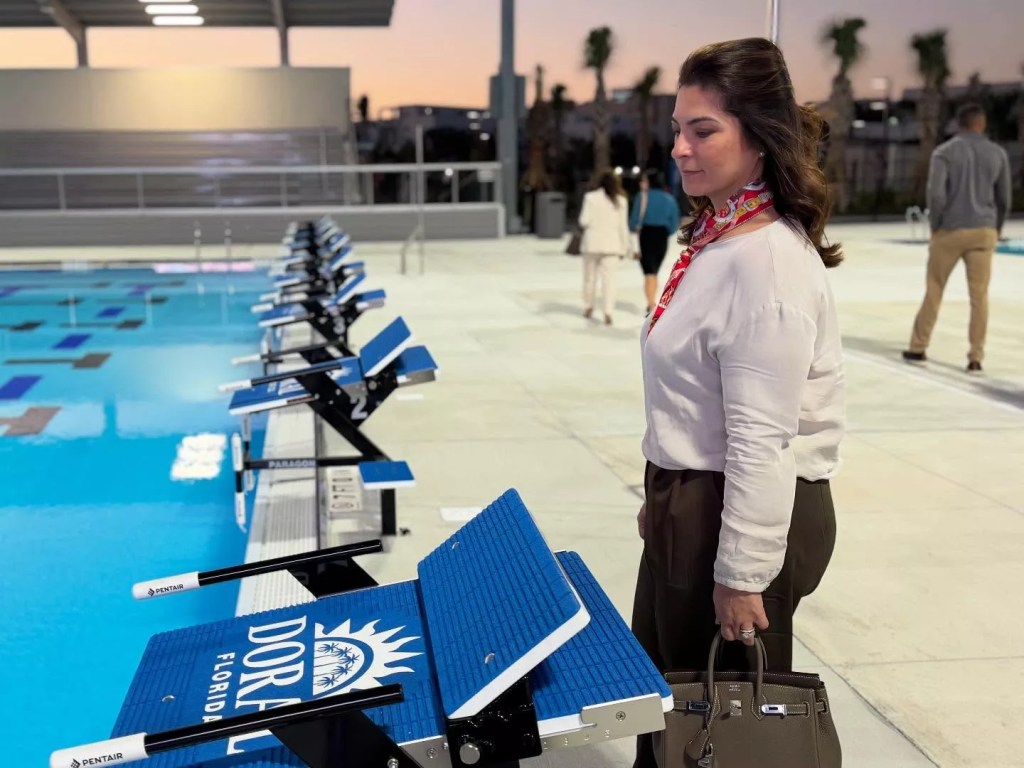 Christi Fraga looks at the community pool holding her birkin bag