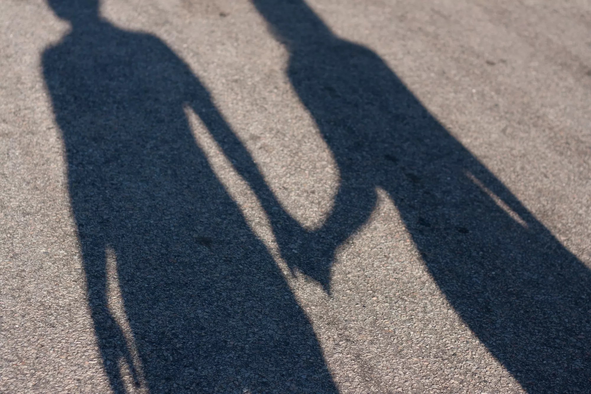 pavement shadow of a couple holding hands