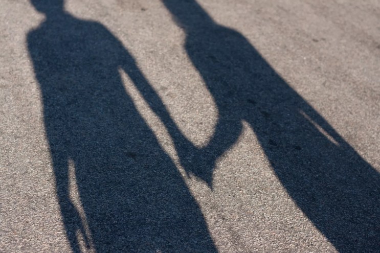 pavement shadow of a couple holding hands