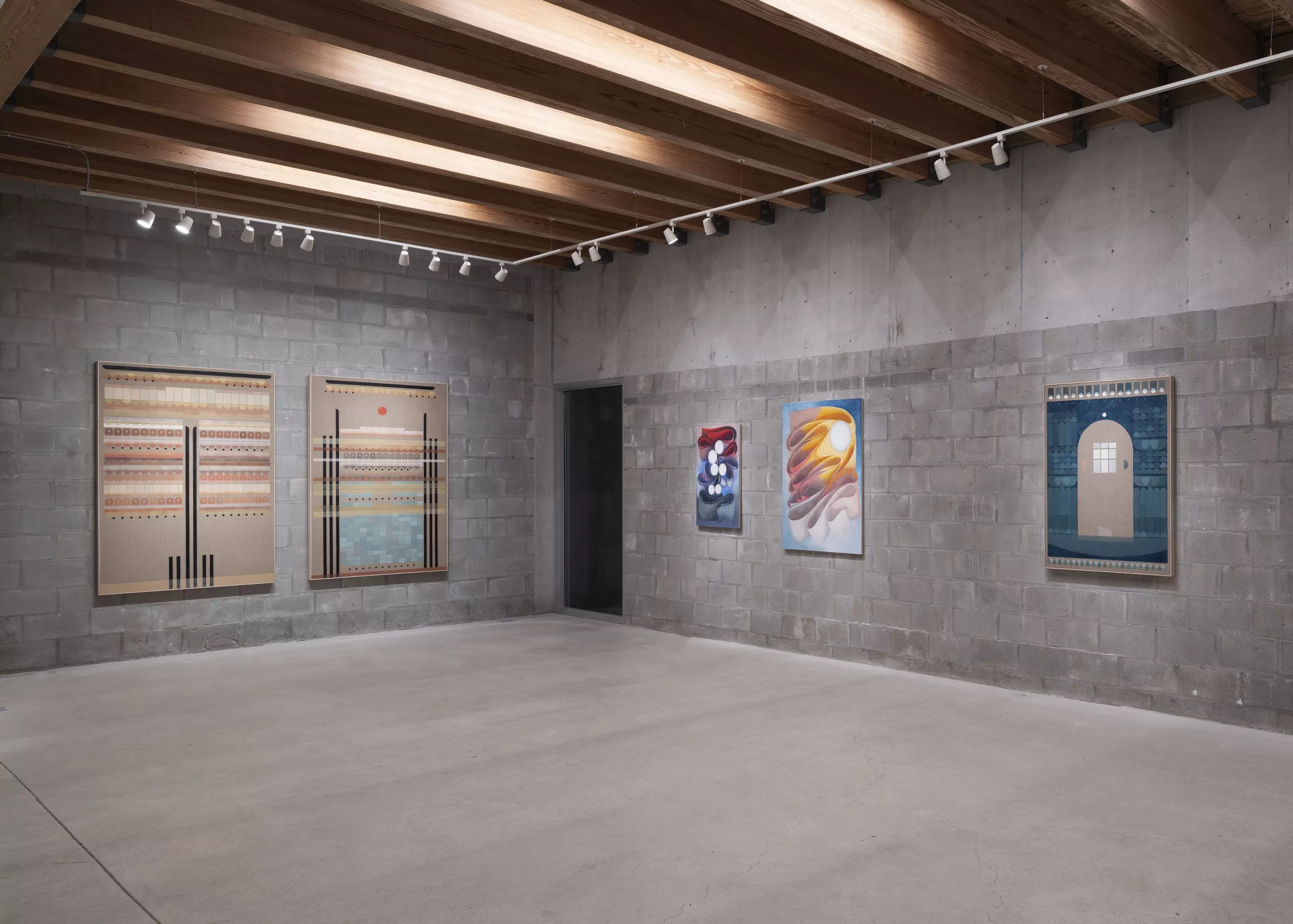 art hangs on gray concrete walls in a museum