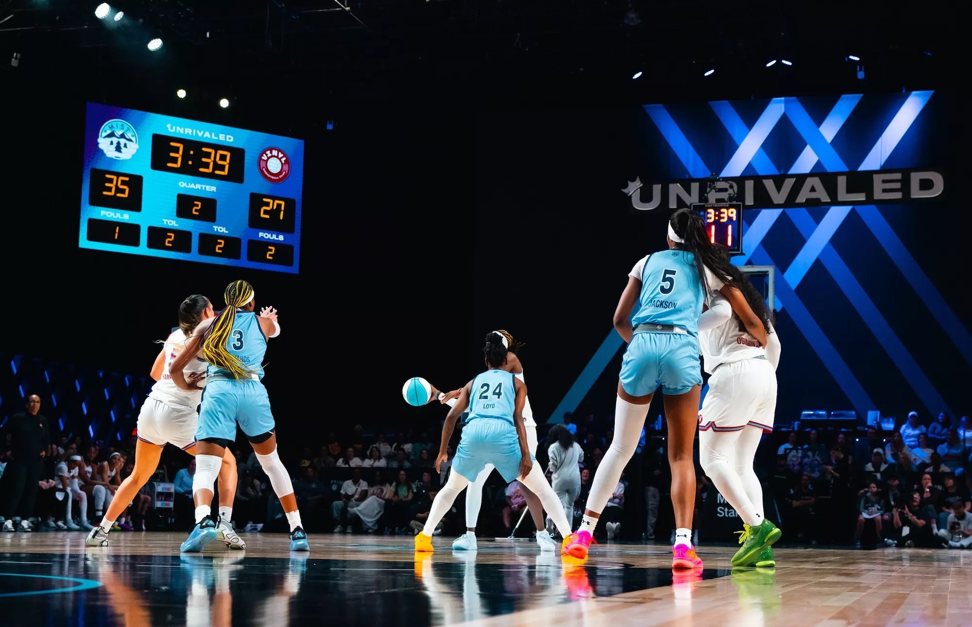two women's basketball teams play on a court