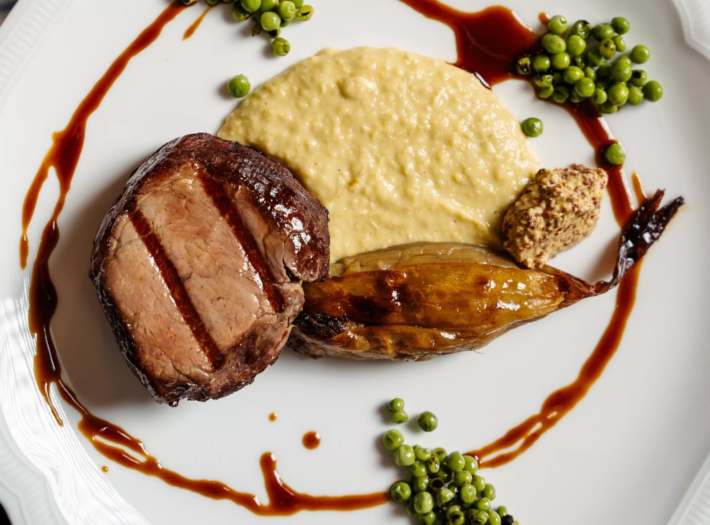 meat dish with potatoes on a white plate