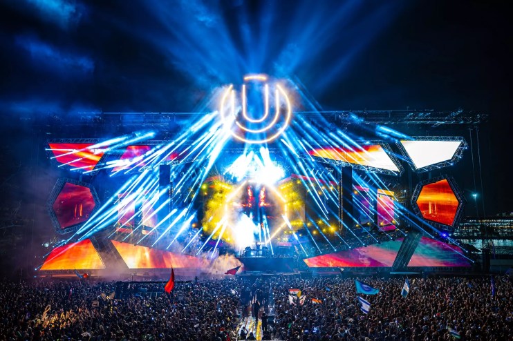 Photo of a stage with colorful LED lights and a u shaped logo.