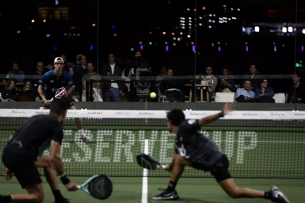 photo of three padel players competing on a court