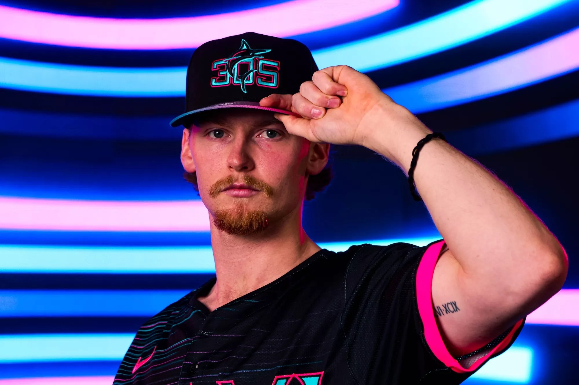 baseball player modeling baseball cap reading "305"