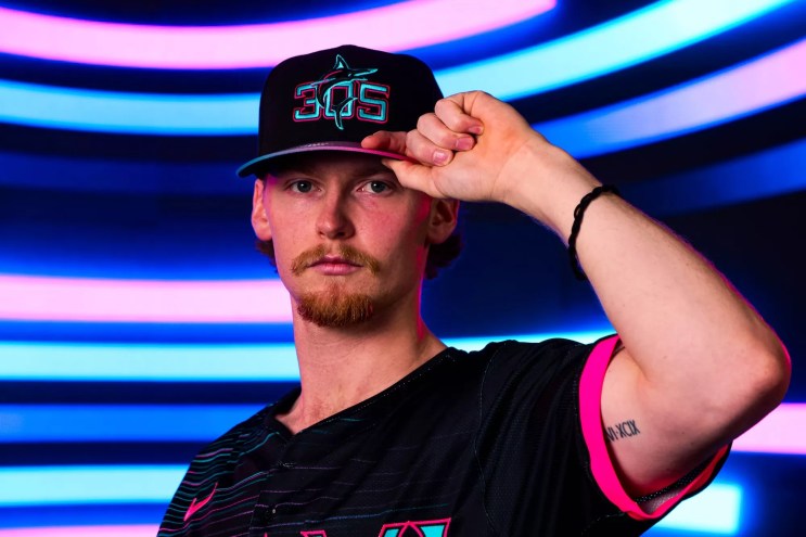 baseball player modeling baseball cap reading "305"