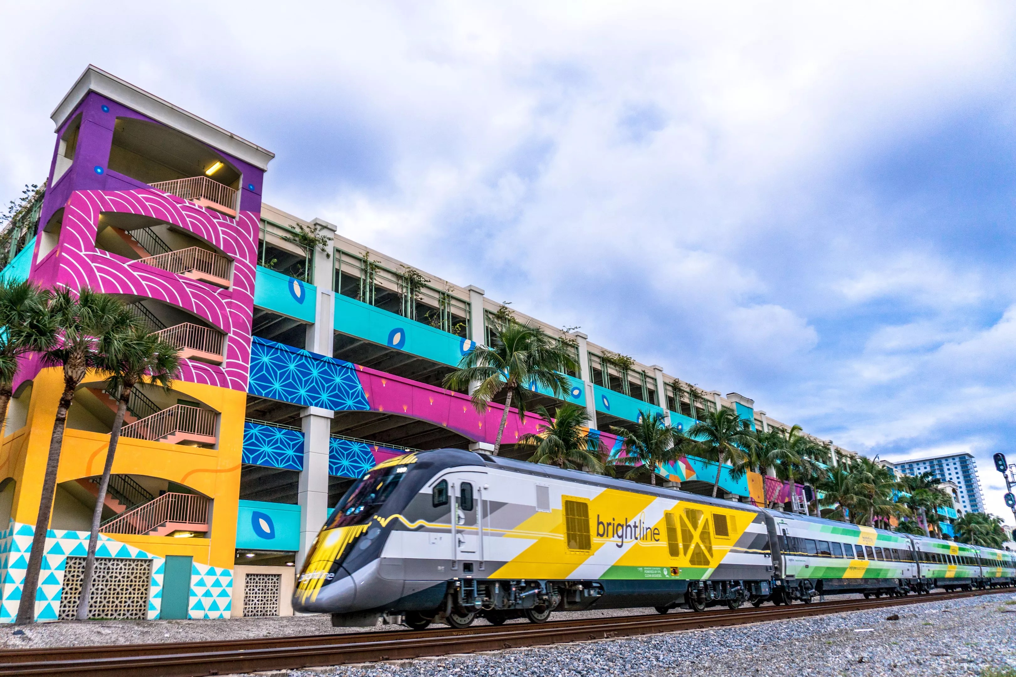 Brightline train in front of colorful parking garage in West Palm Beach