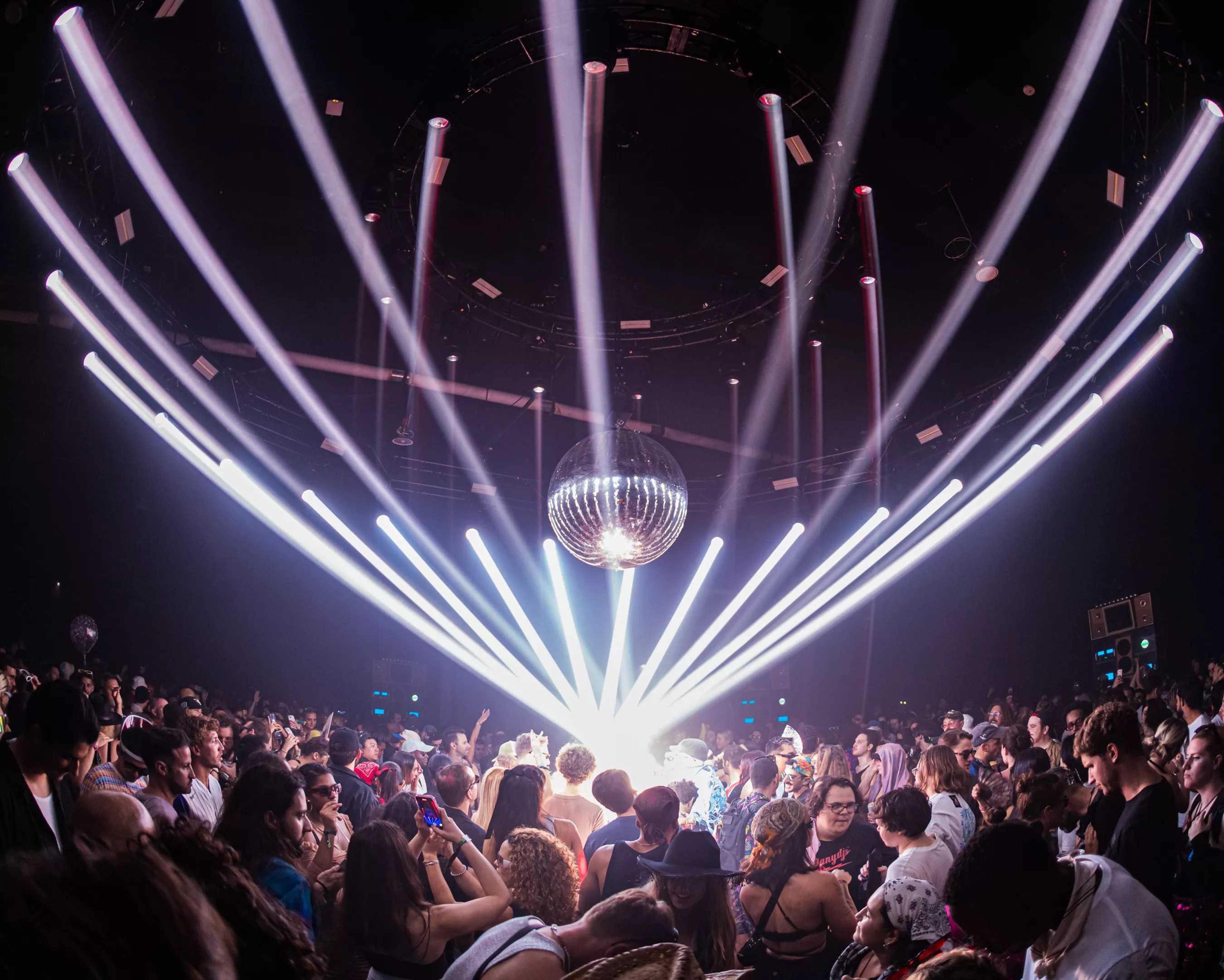 dancers dance on a dance floor underneath a disco ball