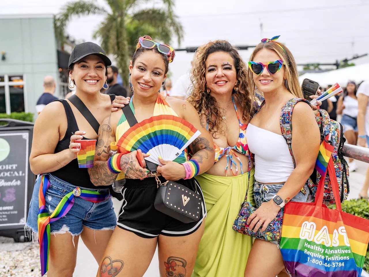 four people pose for the camera at a Pride month party