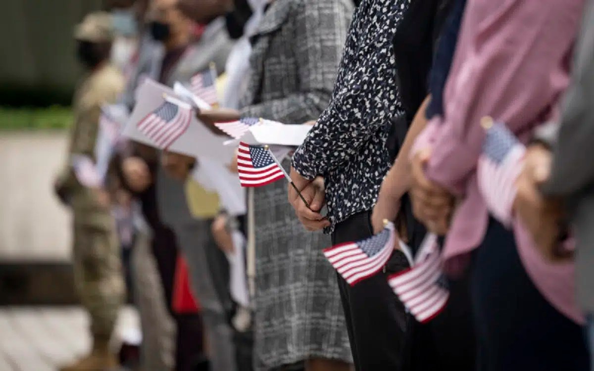 People stand in a line holding Unites States flags.