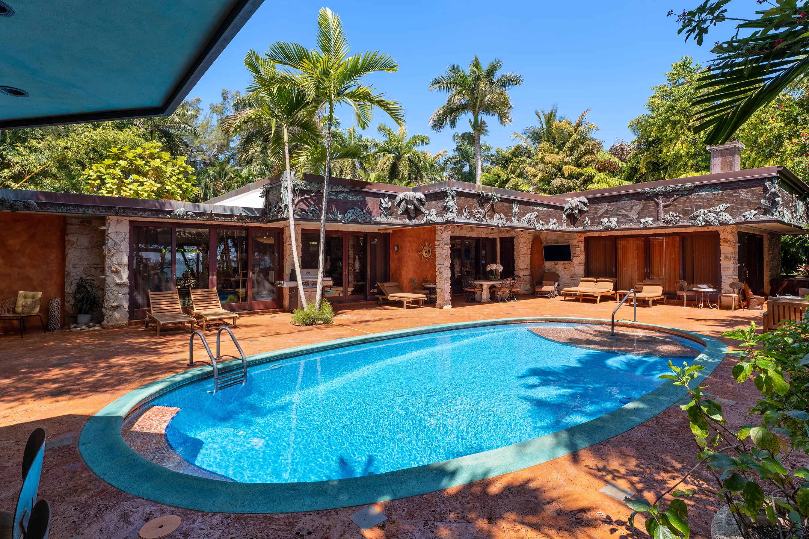 Backyard of Miami Beach house in Morningside. A large oval pool sits in the center.
