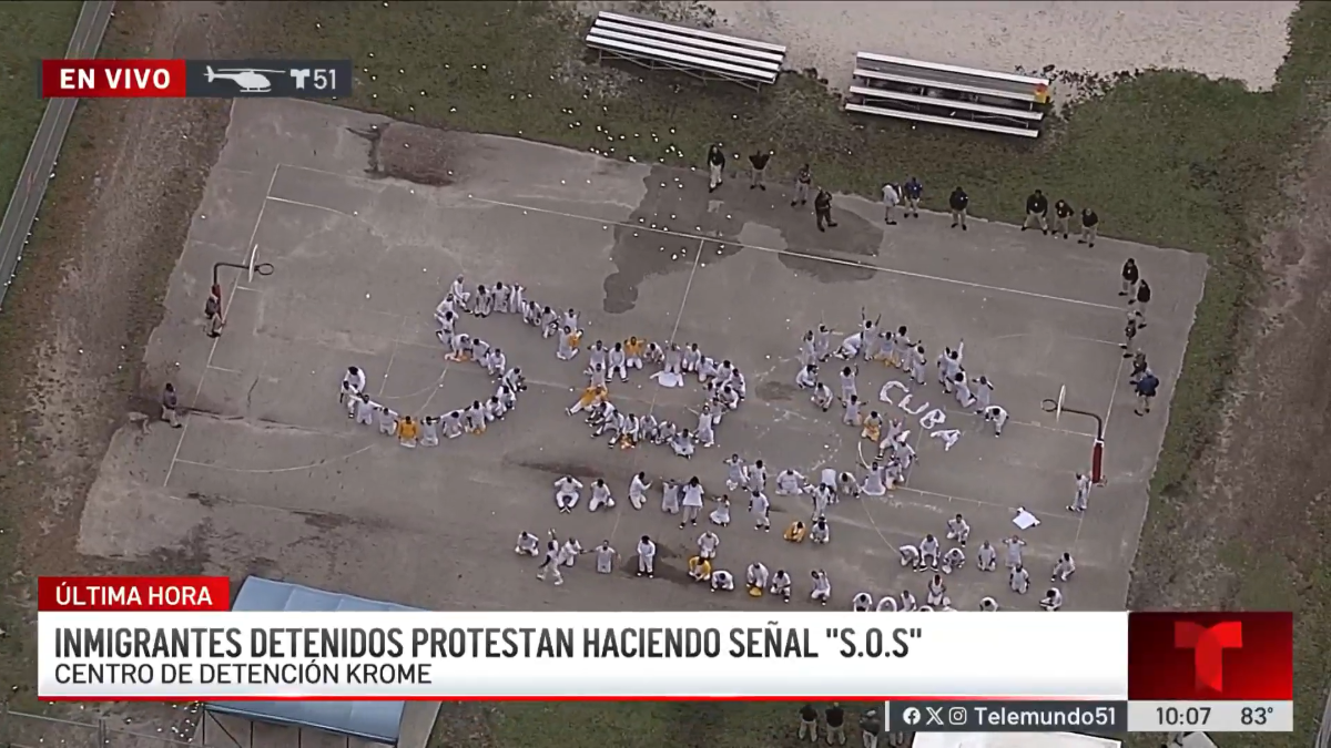 On Thursday morning, a Telemundo news helicopter flew overhead the facility and captured the scene of dozens of men wearing mostly white jumpsuits standing outside the detention center and forming the letters S-O-S.