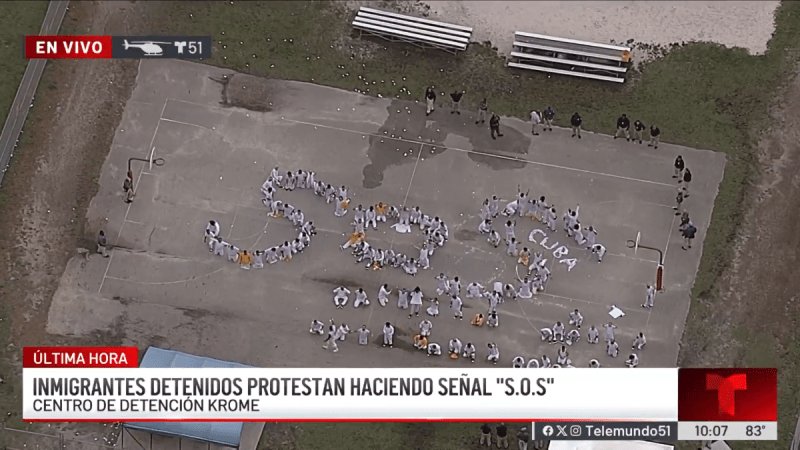 On Thursday morning, a Telemundo news helicopter flew overhead the facility and captured the scene of dozens of men wearing mostly white jumpsuits standing outside the detention center and forming the letters S-O-S.
