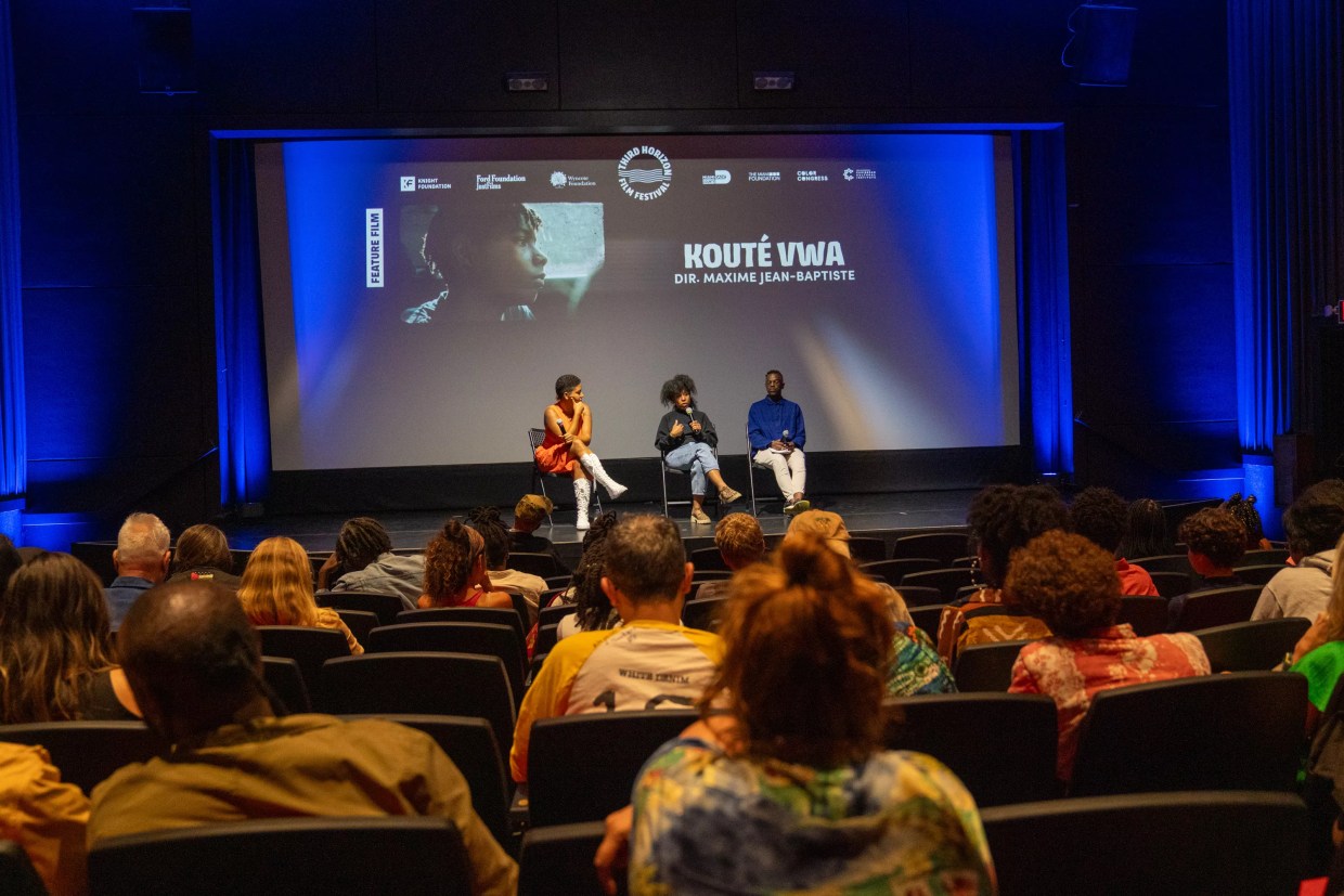 a panel sits on a stage in front of an audience after a movie screening