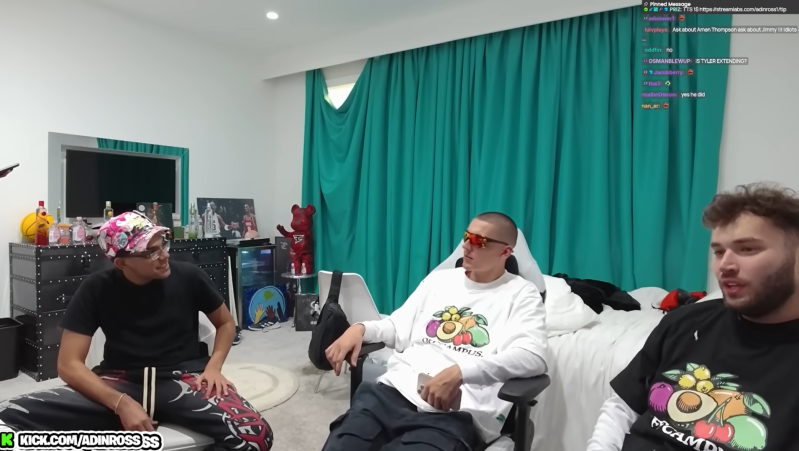 Three young men sit before a Twitch stream with a teal curtain in the background.