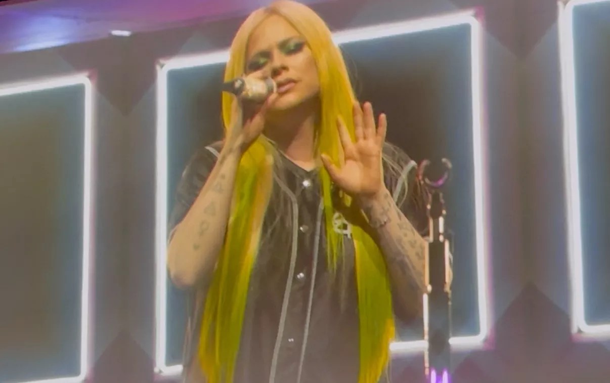 Avril Lavigne sings into a microphone onstage