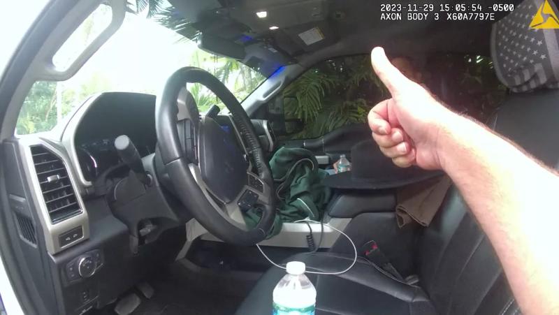 Miami-Dade Police officer gives a thumbs up to one of the officers as he sits in the truck.
