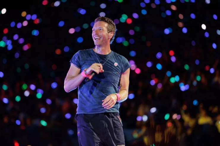 Man with a microphone on stage surrounded by confetti