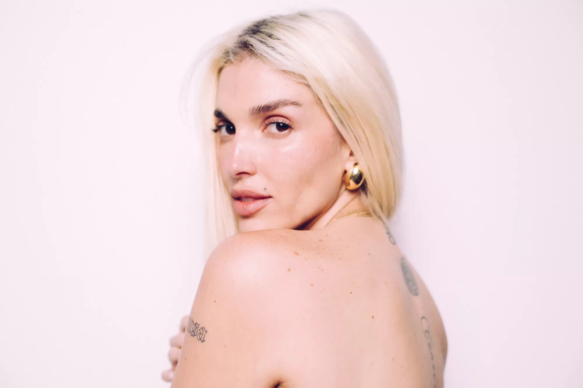 Portrait of a blonde woman with tattoos.