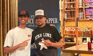 Picture of Chance the Rapper posing with a fan next to a banner.