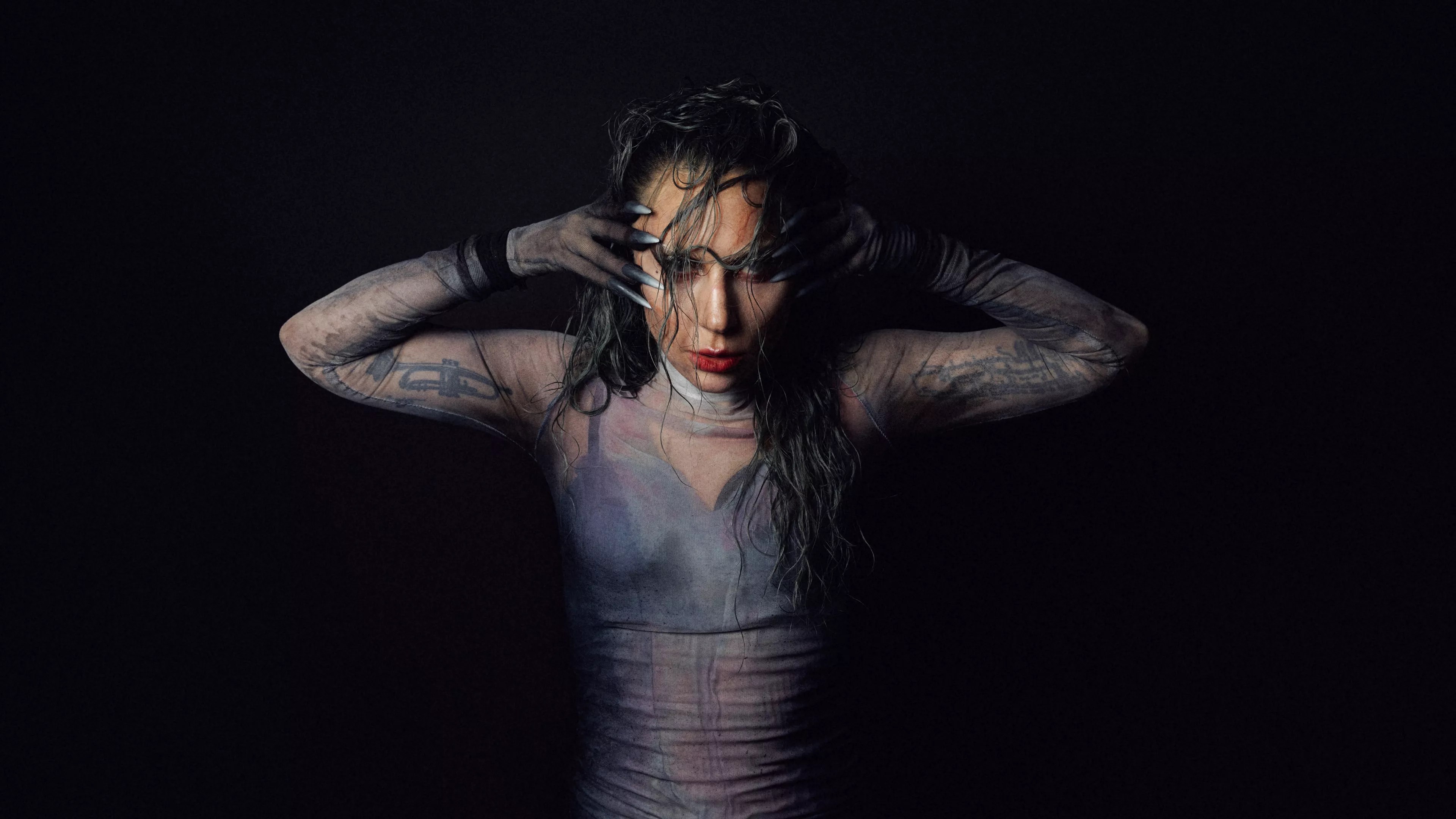 Photo of Lady gaga posing for the camaera with her hands on the side of her face.