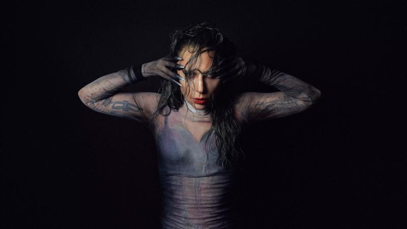 Photo of Lady gaga posing for the camaera with her hands on the side of her face.