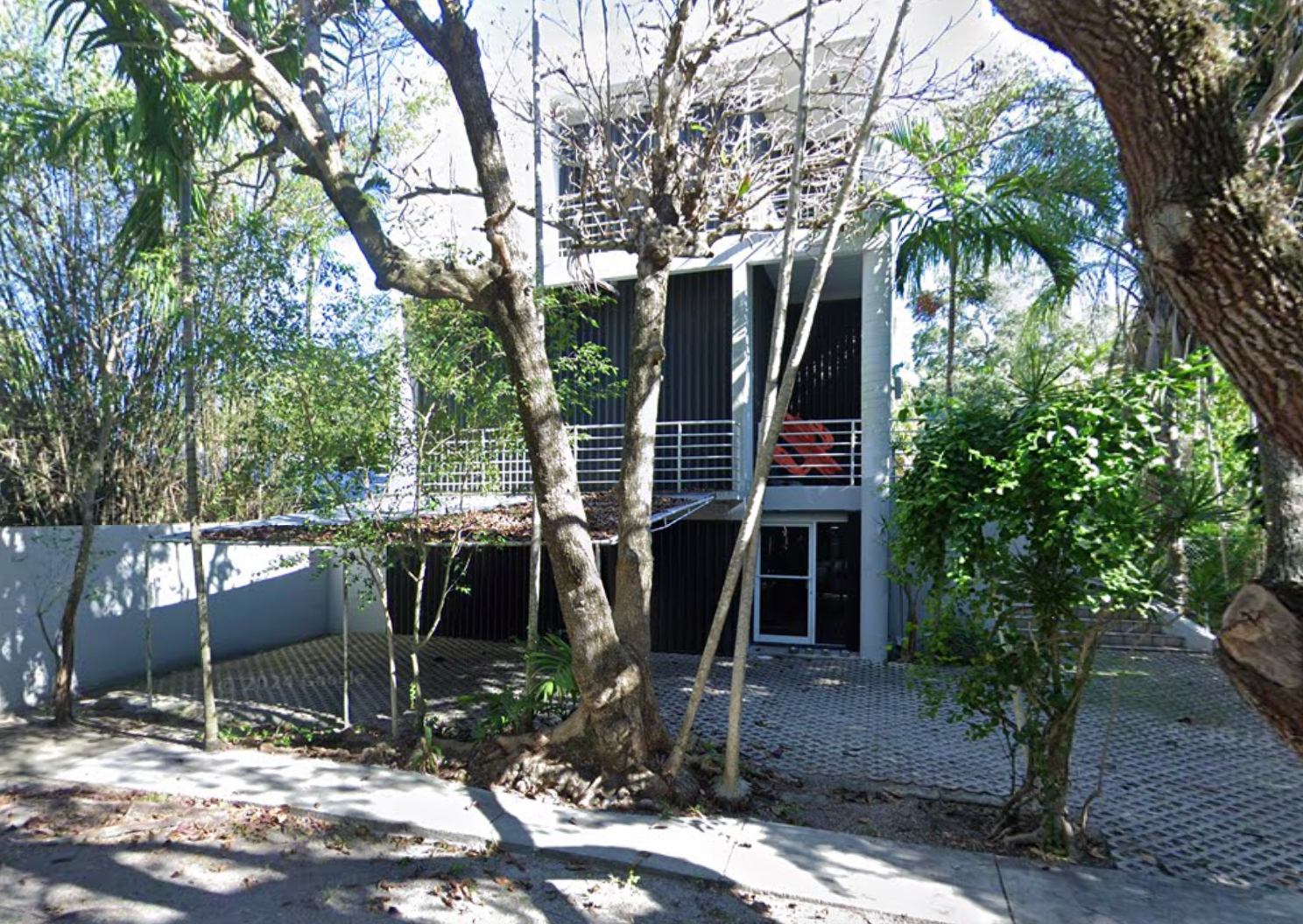 Google Maps screenshot of a three-story villa surrounded by trees and palms