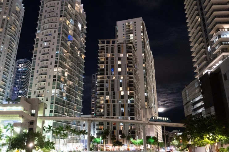 Brickell skyline by night with Metromover crossing bridge in the foreground